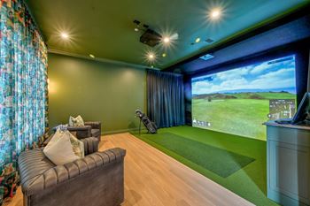 A room with a couch, a television, and a large screen showing a golf game.